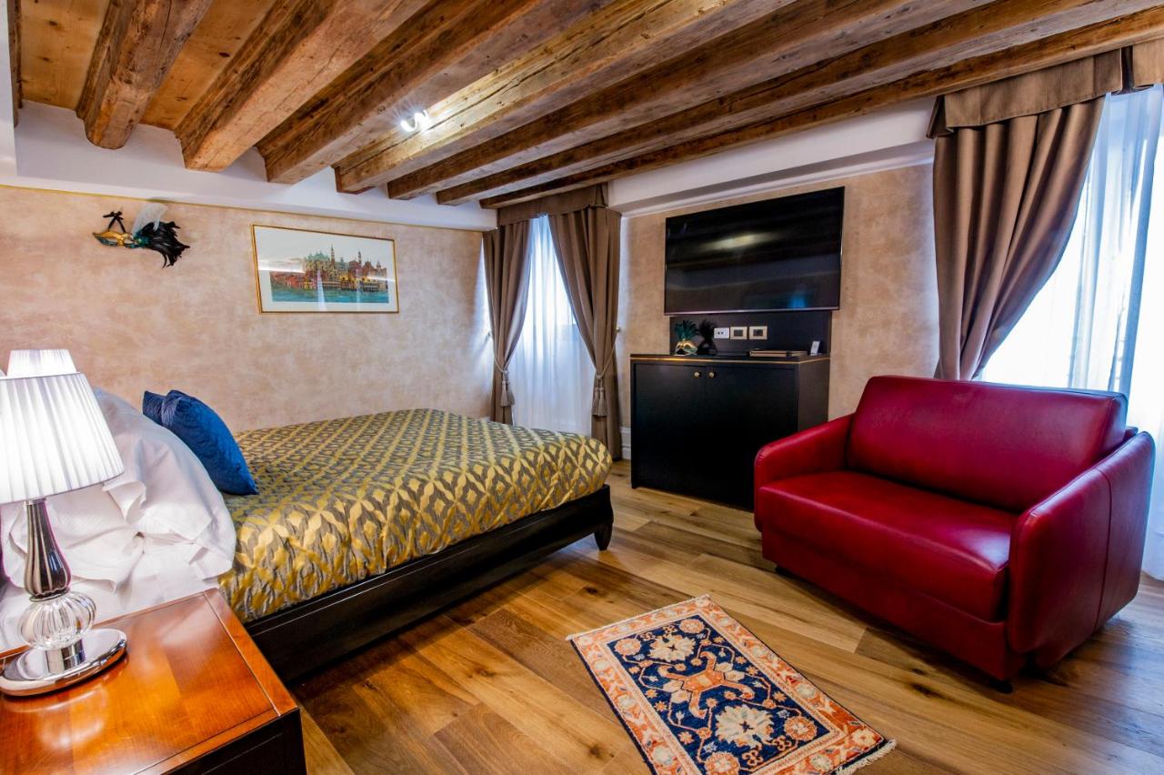 een slaapkamer met een bed en een rode stoel bij EGO' Residence Venice in Venetië +24 foto's