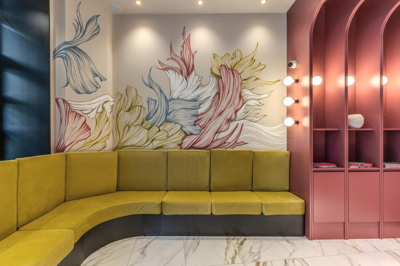 een lobby met een groene bank en een schilderij aan de muur bij Madison Hotel in Rome