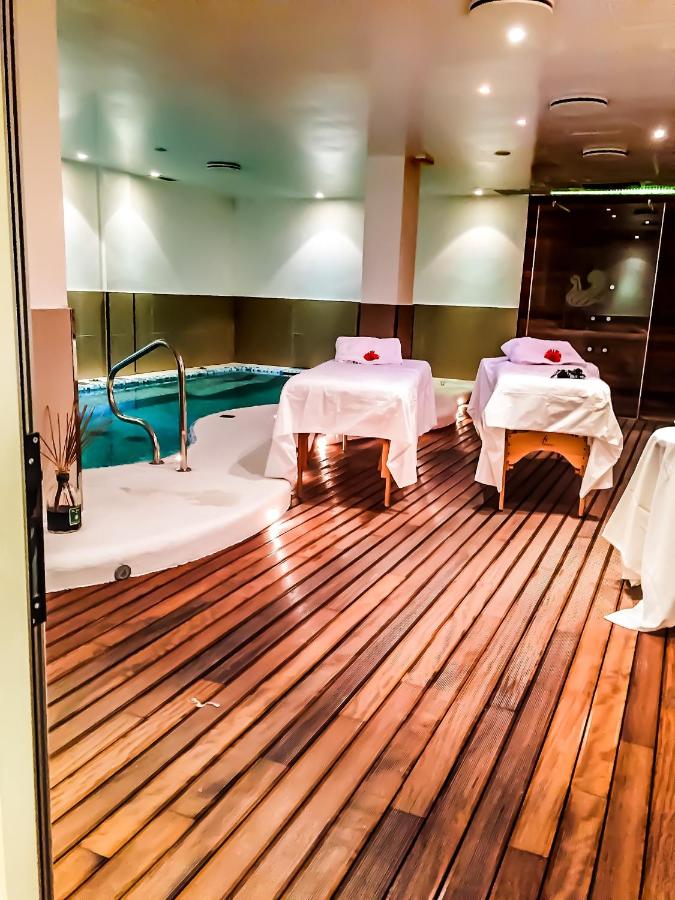 een spakamer met twee bedden en een badkuip bij Punta Campanella Resort & Spa in Massa Lubrense