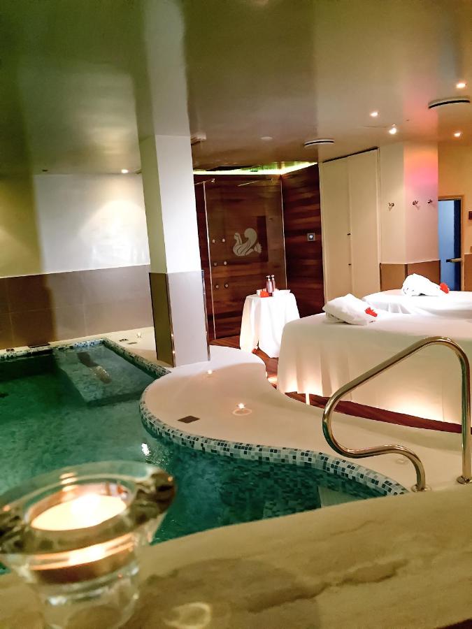 een badkamer met een badkuip, een bed en een wastafel bij Punta Campanella Resort & Spa in Massa Lubrense