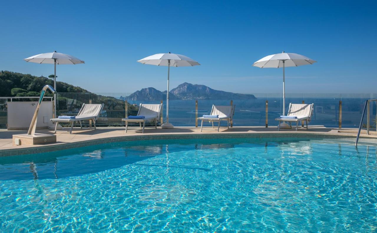 een groot zwembad met ligstoelen en parasols bij Hotel & Spa Bellavista Francischiello in Massa Lubrense