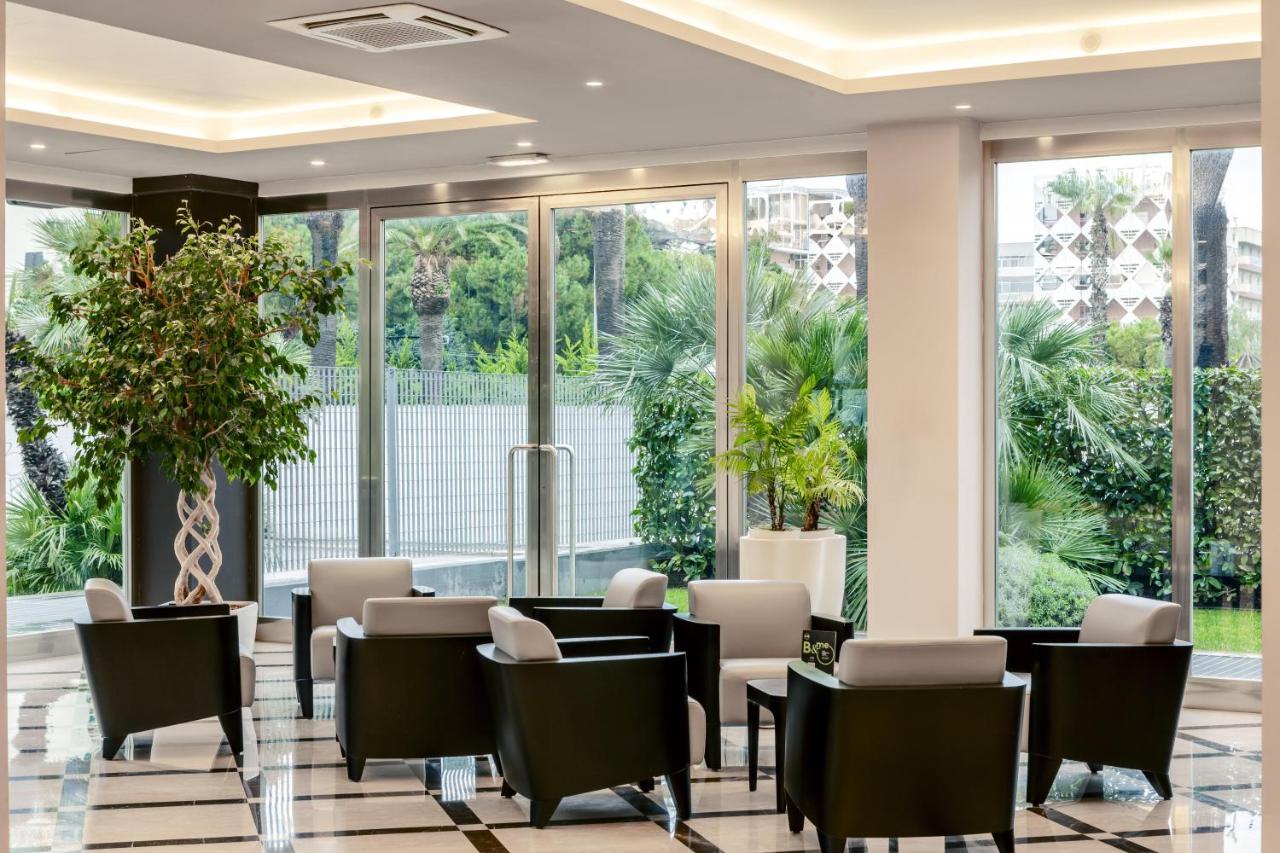 een wachtkamer met tafels en stoelen en grote ramen bij B&B HOTEL Bari Rondò in Bari