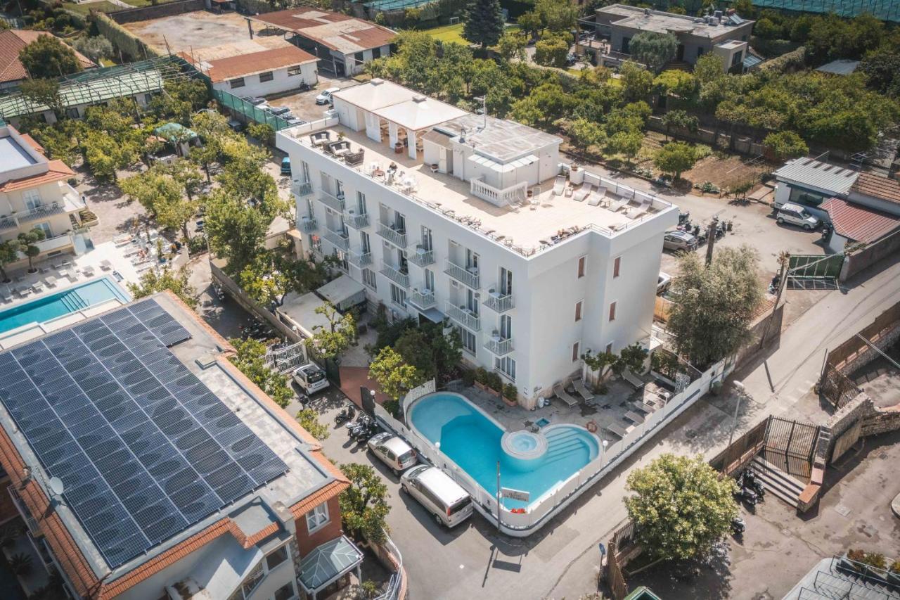 Een luchtfoto van een groot wit gebouw met een zwembad. bij Hotel La Pergola in Sant'Agnello