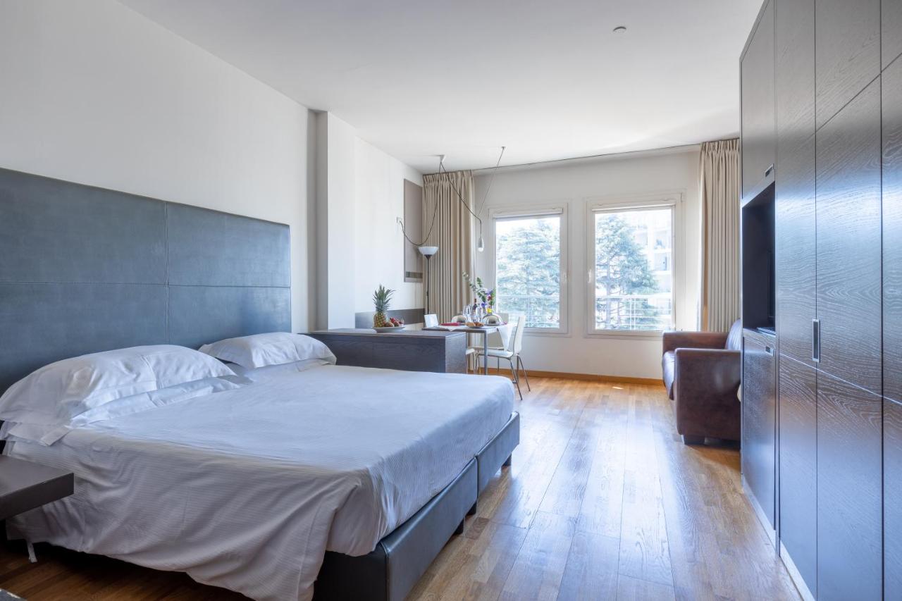 een slaapkamer met een groot bed en een bureau bij Wall Art Hotel & Residence in Prato