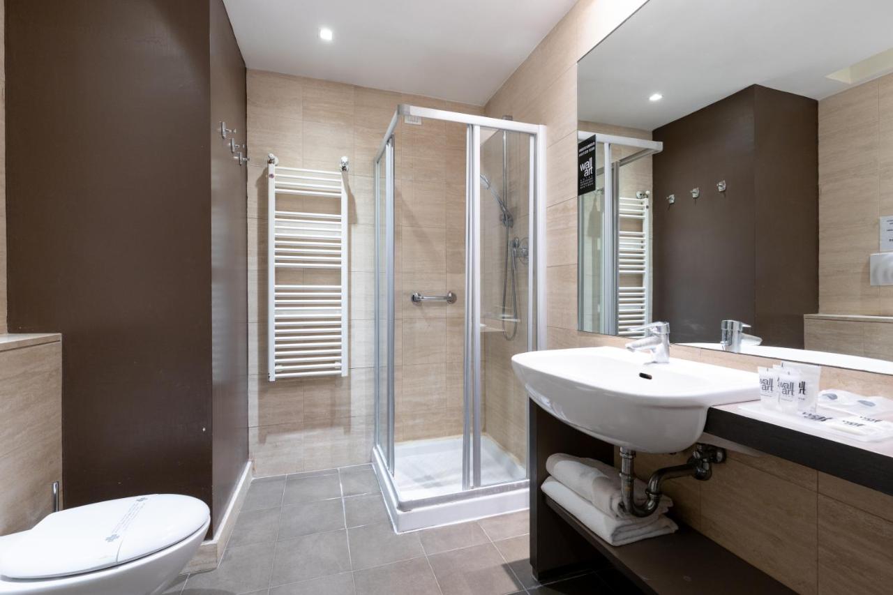 een badkamer met een douche, een wastafel en een toilet. bij Wall Art Hotel & Residence in Prato