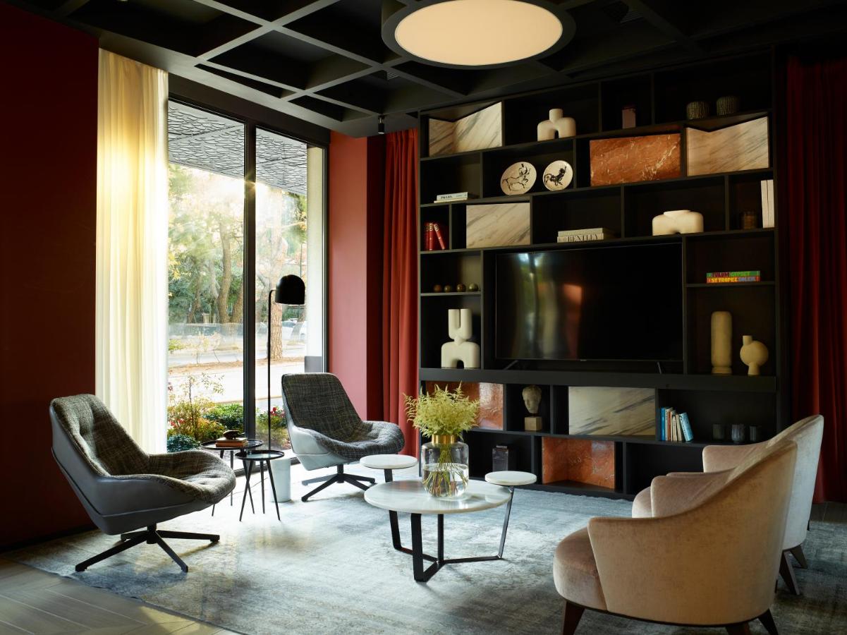 een woonkamer met stoelen en een tv bij SAY HOTEL in Athene