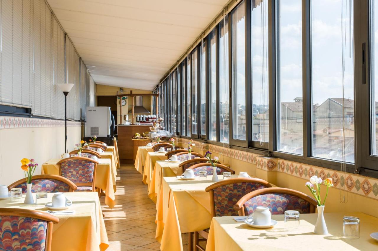 een rij tafels in een restaurant met ramen bij Hotel Fiorita in Florence