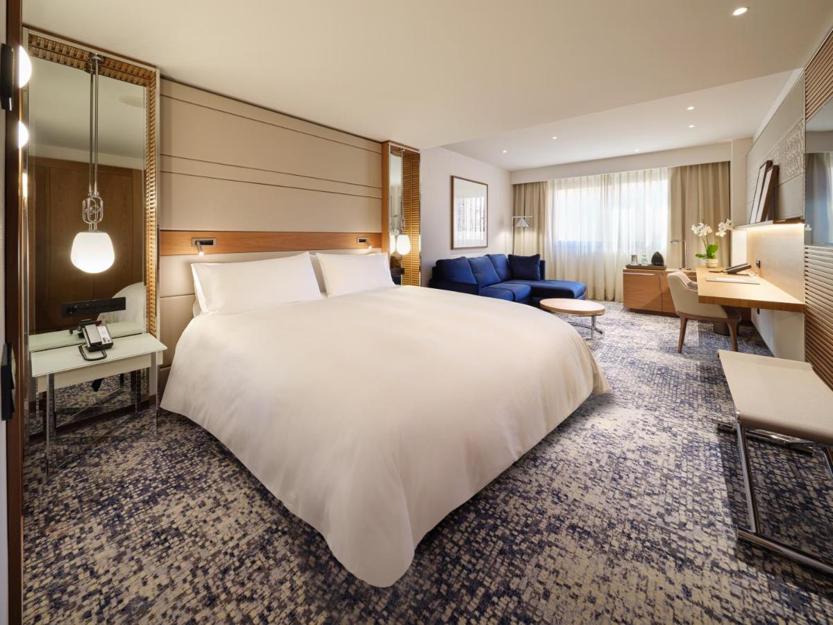 een hotelkamer met een groot bed en een woonkamer bij InterContinental Barcelona by IHG in Barcelona