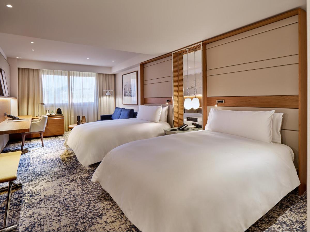 een hotelkamer met twee bedden en een bureau bij InterContinental Barcelona by IHG in Barcelona
