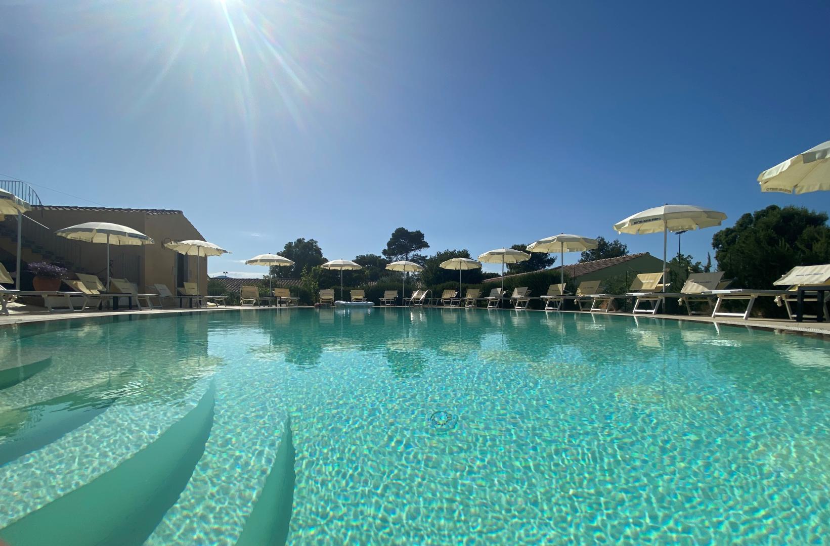 Zwembad omringd door palmbomen — Cala Mirto
