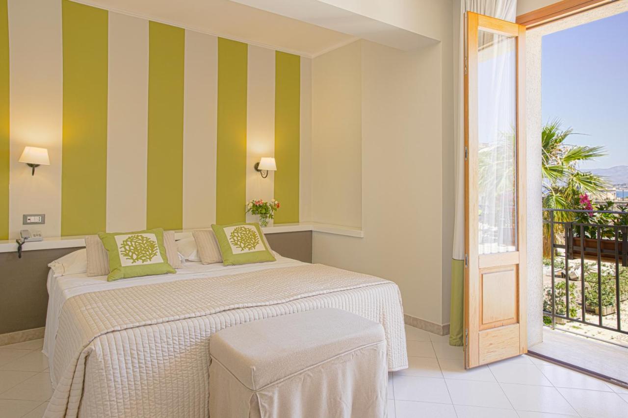 een slaapkamer met een bed met groene en witte strepen bij Hotel Al Madarig in Castellammare del Golfo
