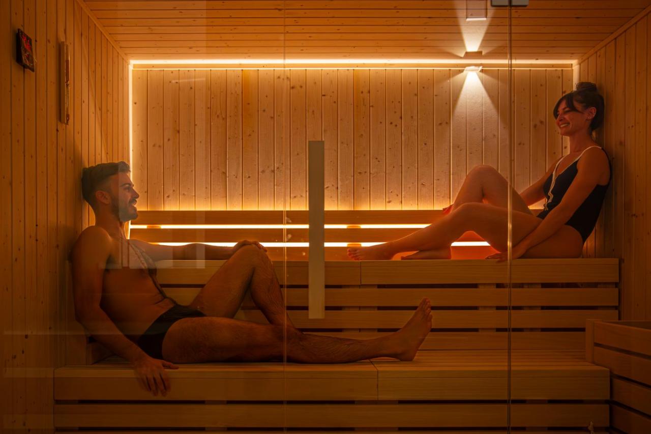 een man en een vrouw zitten in een sauna bij Hotel Al Madarig in Castellammare del Golfo