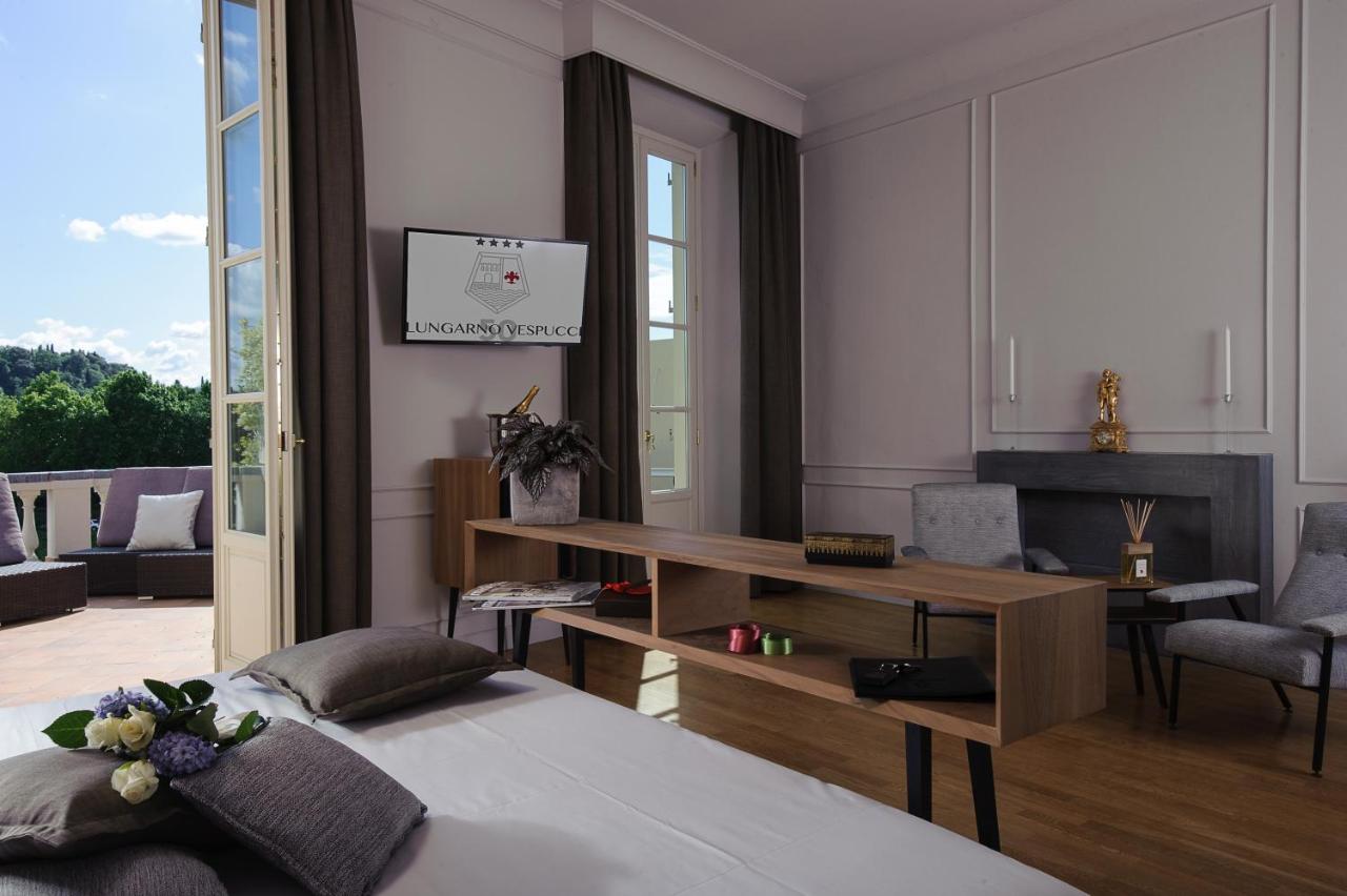 een kamer met een bed, een bureau en een tafel bij Hotel Lungarno Vespucci 50 in Florence