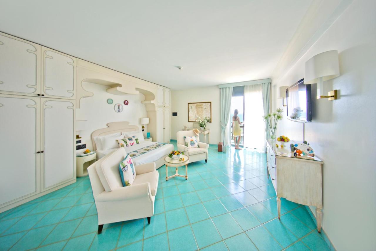 een grote kamer met twee stoelen en een bed erin bij Grand Hotel Terme in Margherita di Savoia