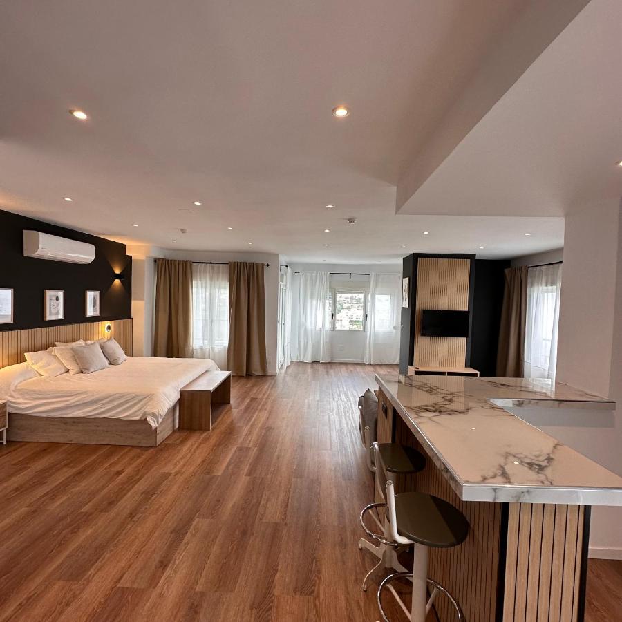 een grote slaapkamer met een bed en een keuken bij First Flatotel International in Benalmádena