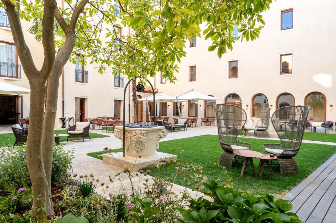 een binnenplaats met stoelen en een boom voor een gebouw bij Ca' di Dio - VRetreats, an SLH Hotel in Venetië