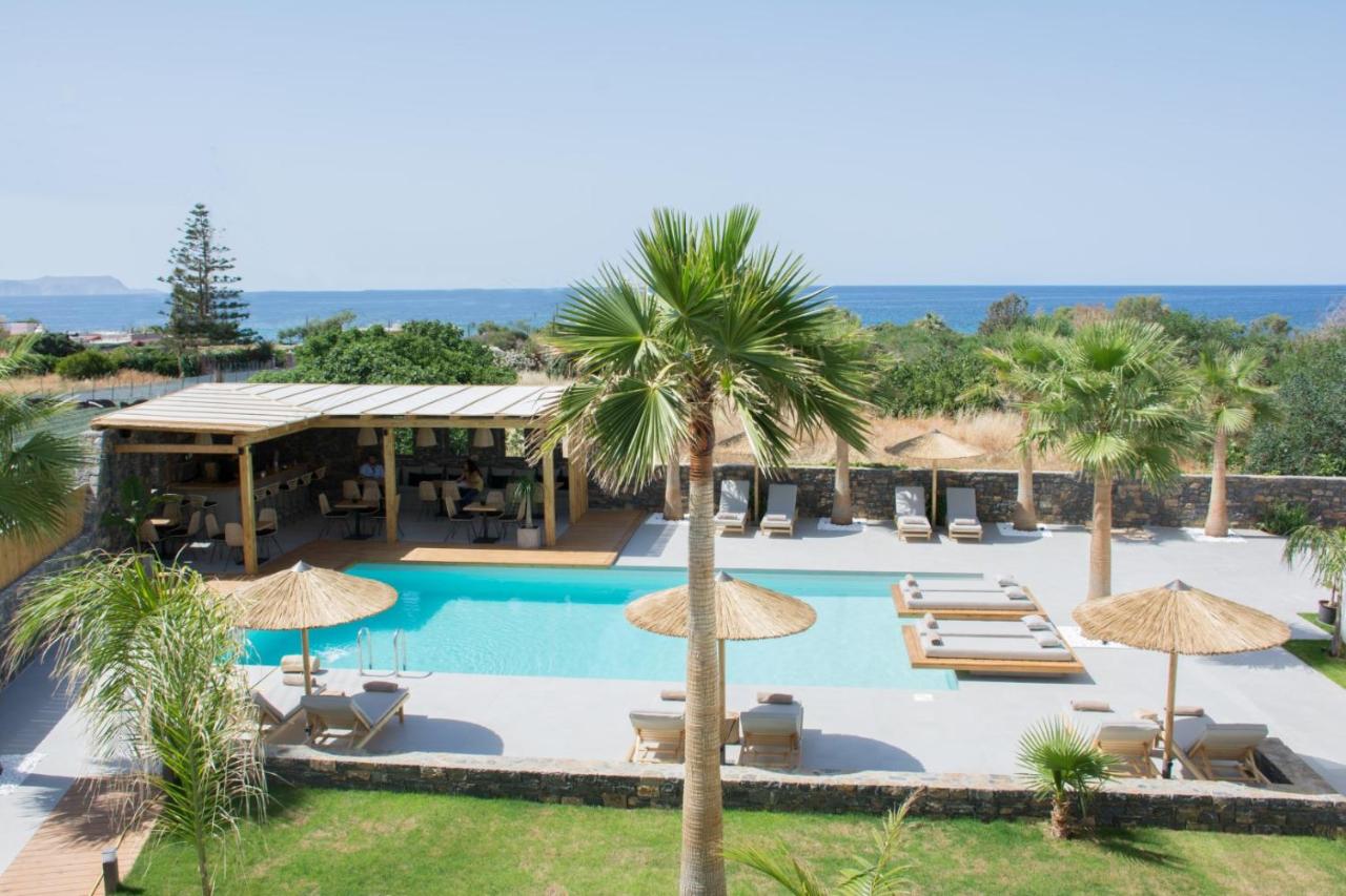 een zwembad met palmbomen en parasols bij Aqua Blu "Adults Only" - "by Checkin" in Chersonissos