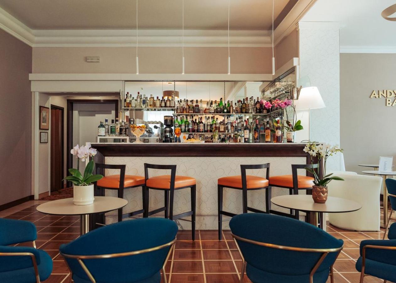 een restaurant met tafels en stoelen en een bar bij Hotel Flora in Stresa