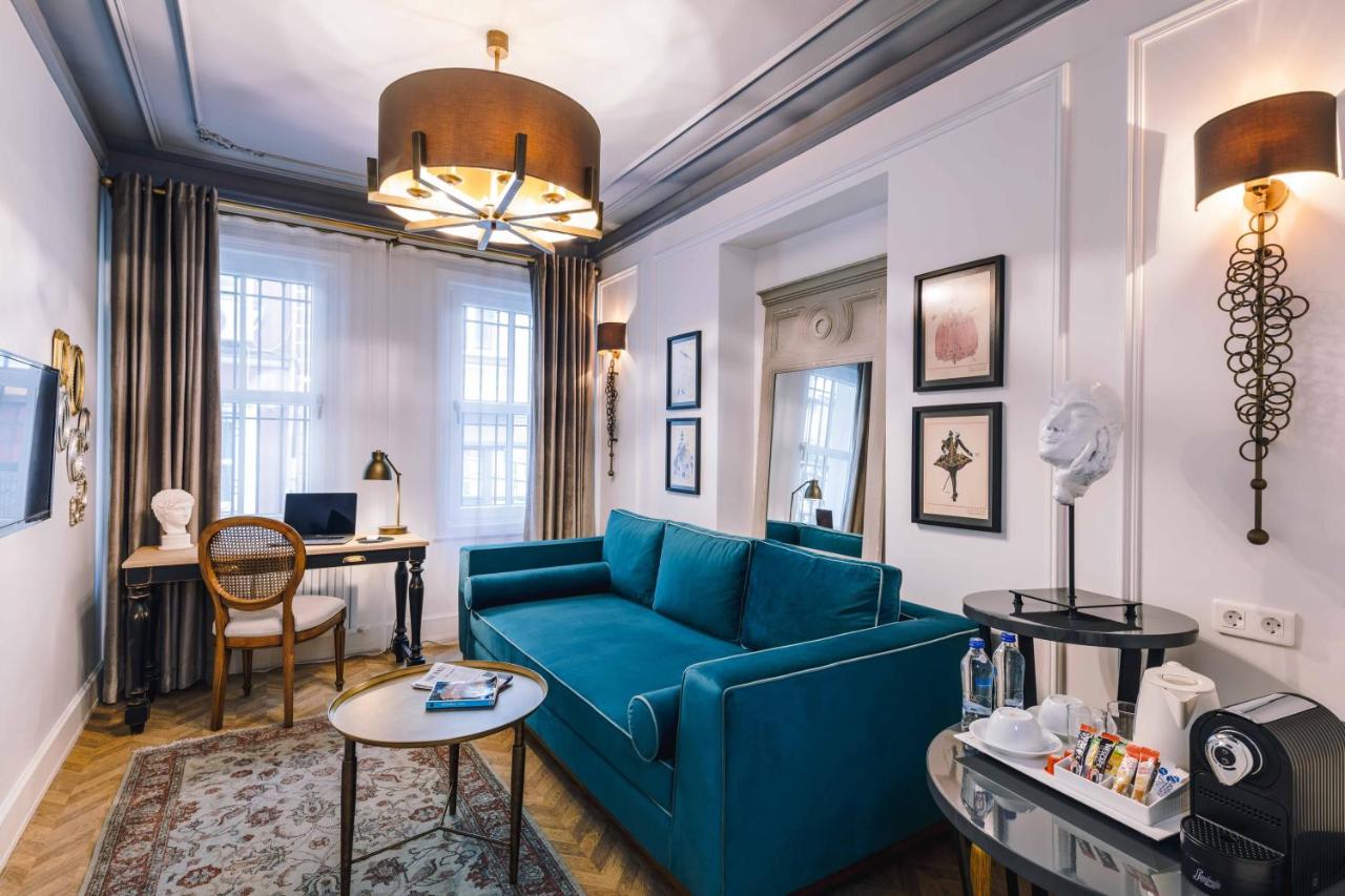 een woonkamer met een blauwe bank en een tafel bij The Soul Istanbul Hotel in Istanbul