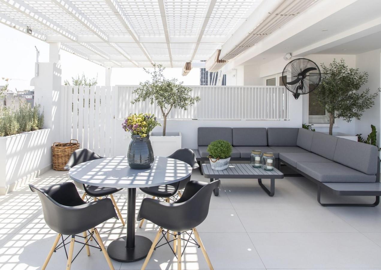 een terras met een bank, een tafel en stoelen bij Gallery Suites & Residences Piraeus in Piraeus