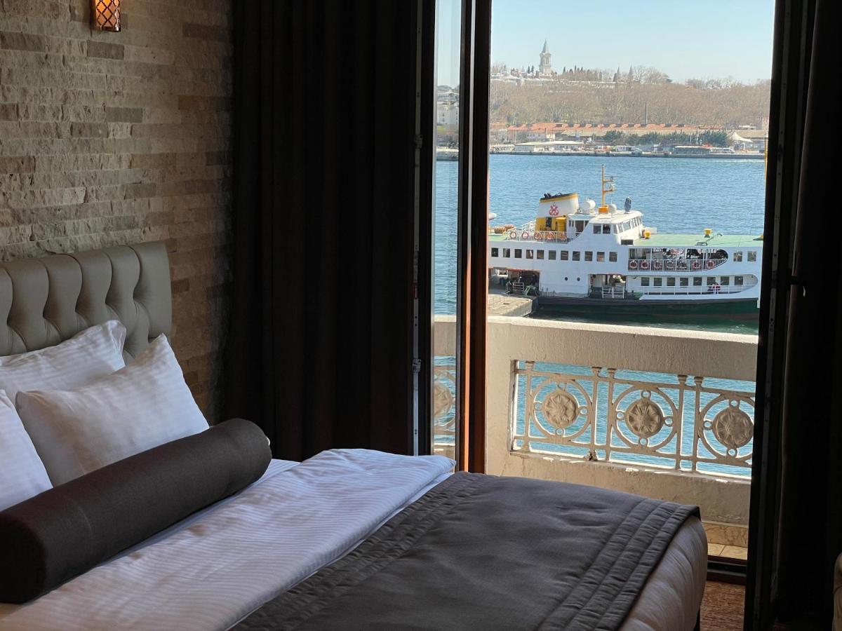 een slaapkamer met uitzicht op een boot op het water bij Weingart Seaside Hotel in Istanbul
