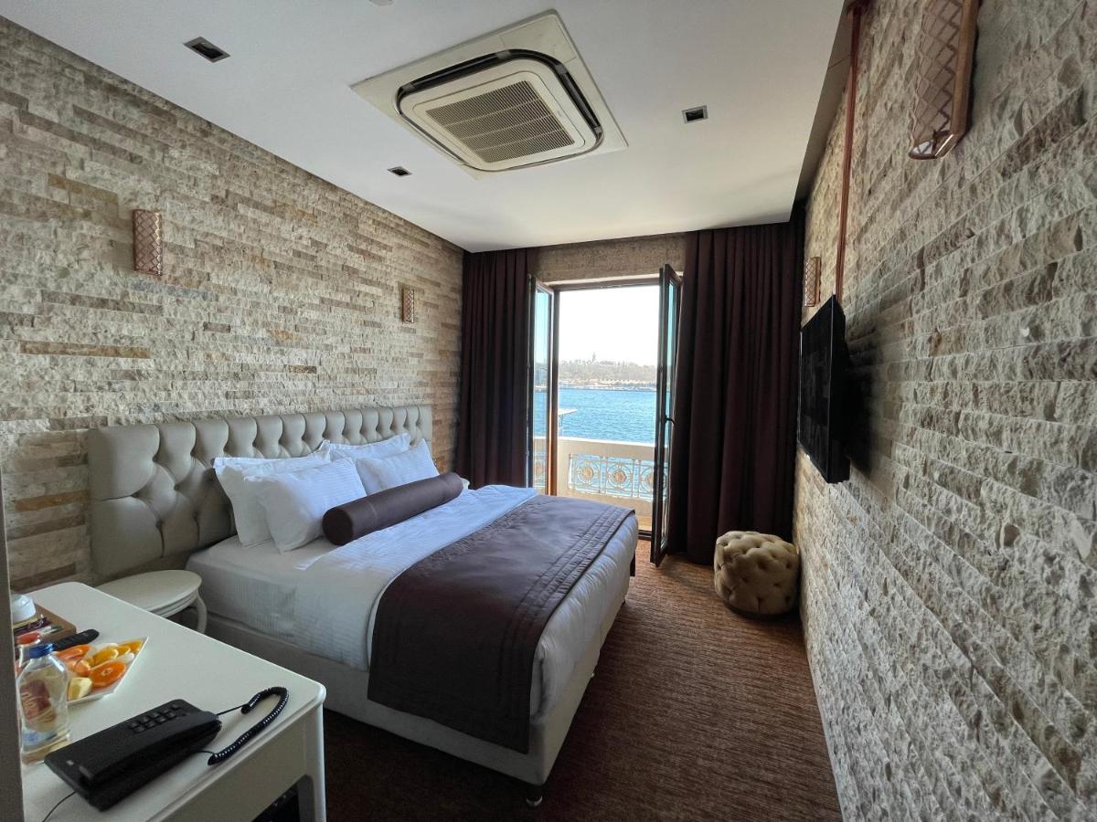 een slaapkamer met een bed en een bakstenen muur bij Weingart Seaside Hotel in Istanbul