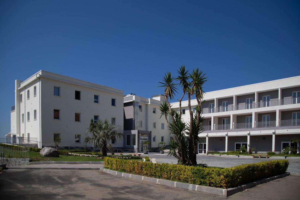 een rij gebouwen met palmbomen op een parkeerplaats bij GRAND HOTEL SERAPIDE in Pozzuoli