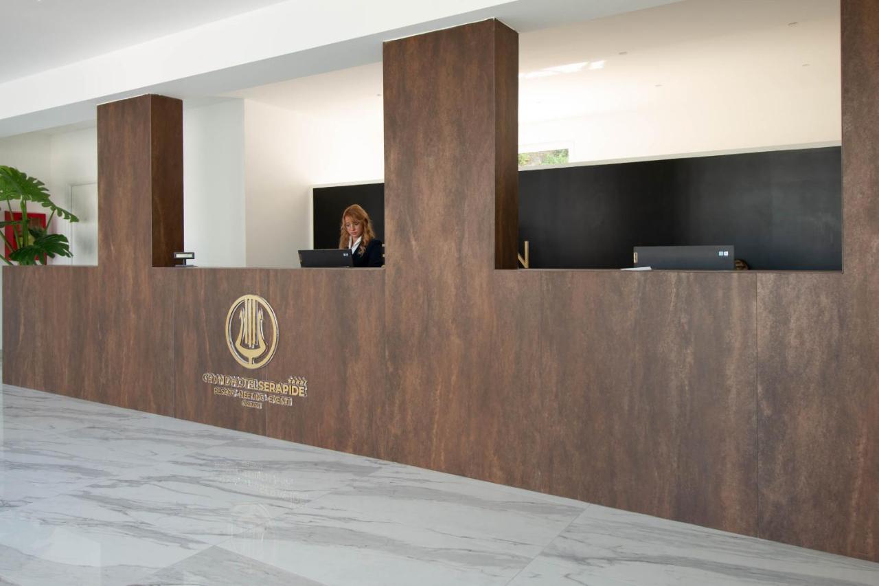 Een vrouw zit aan een receptiebalie. bij GRAND HOTEL SERAPIDE in Pozzuoli +74 foto's
