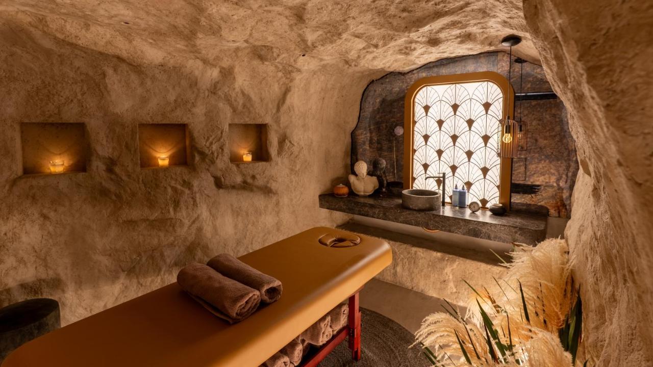 een badkamer in een grot met een tafel en een raam bij Gatsby Athens in Athene