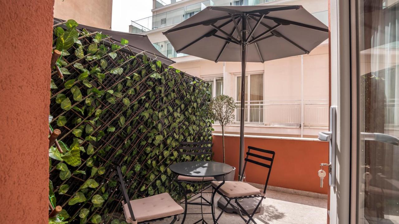 een tafel en stoelen met een parasol op een balkon bij Metis Urbane Living Spaces in Athene +62 foto's