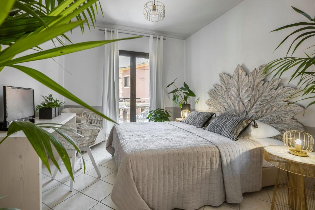 een slaapkamer met een bed en een groot raam bij Makis Hotel in Skála Kefalonias