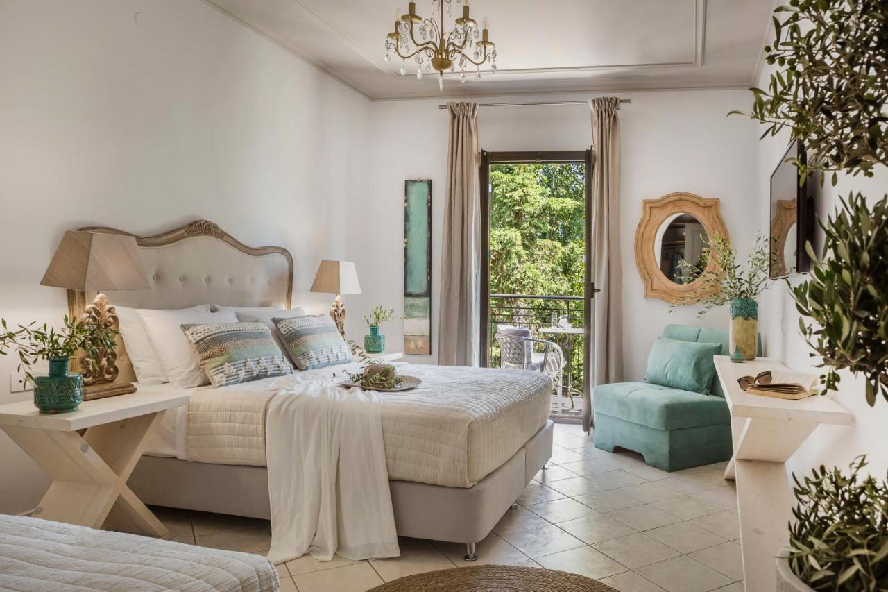een slaapkamer met een bed, een stoel en een raam bij Makis Hotel in Skála Kefalonias