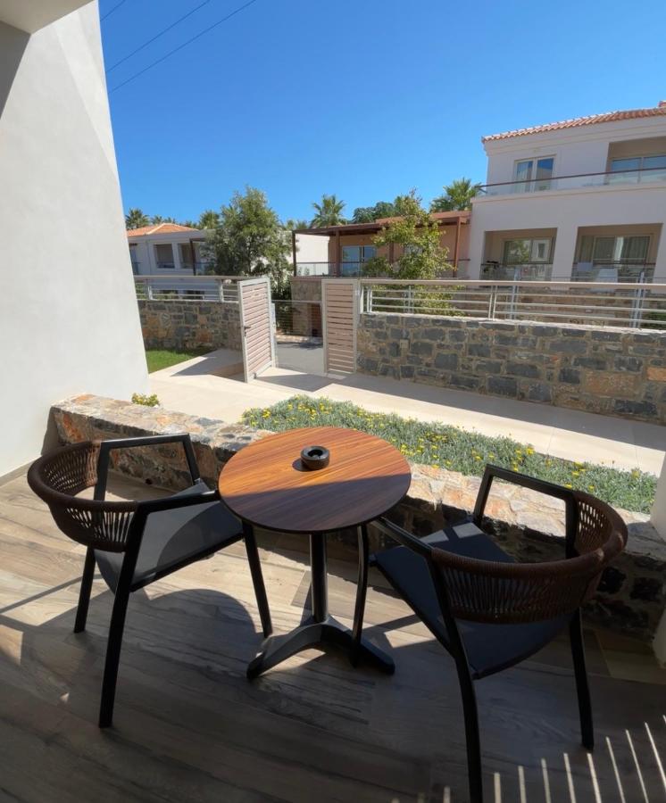 een houten tafel en twee stoelen op een terras bij Theasea Stylish Residences in Panormos Rethymno