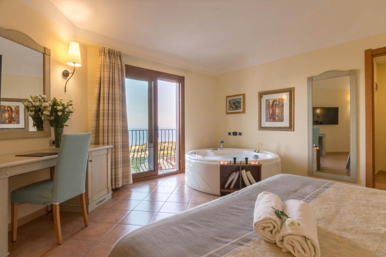 een slaapkamer met een badkuip, een bureau en een bed bij Hotel Brancamaria Gulf of Orosei Boat Tour in Cala Gonone