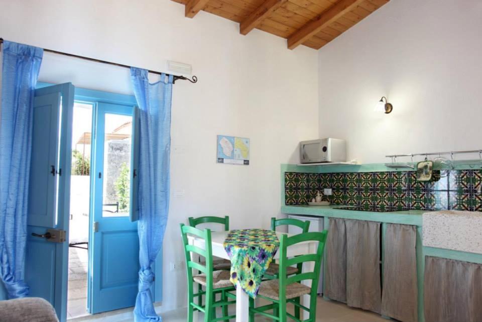 een keuken met een tafel en stoelen en een blauwe deur bij Dimora Da Tito - La Corte dei Colori in Spongano