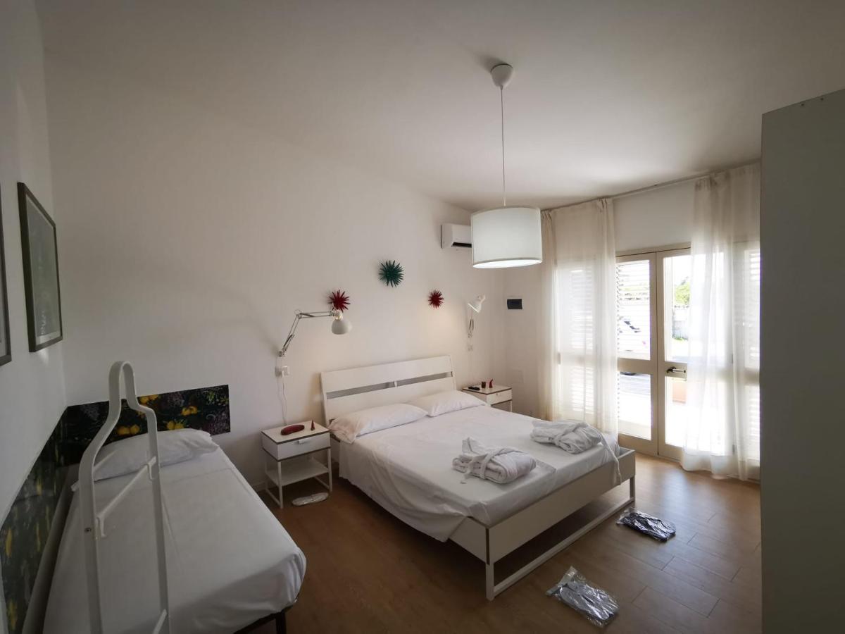 een witte slaapkamer met een bed en een raam bij Il Giardino dei Pini in Paestum