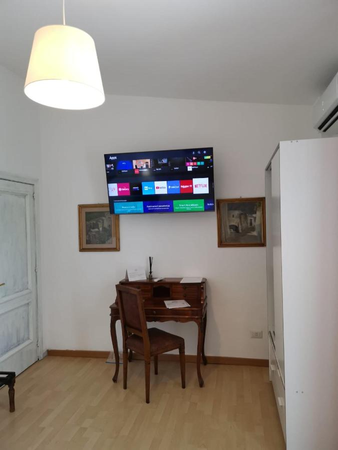 een kamer met een tafel en een televisie aan de muur bij Il Giardino dei Pini in Paestum +10 foto's