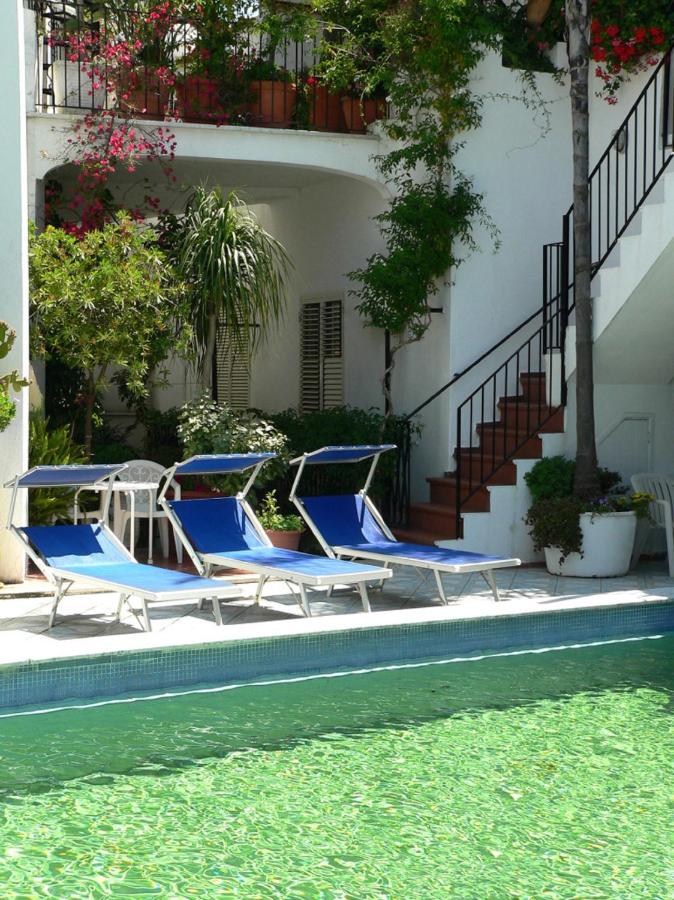 twee blauwe ligstoelen naast een zwembad bij Hotel la Maggioressa in Casamicciola Terme