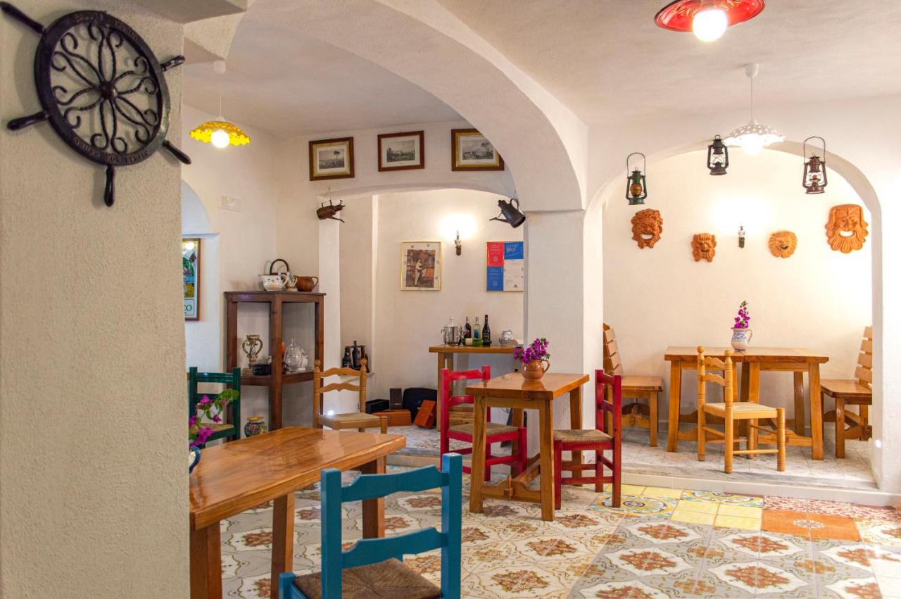 een kamer met tafels, stoelen en een klok bij Hotel la Maggioressa in Casamicciola Terme