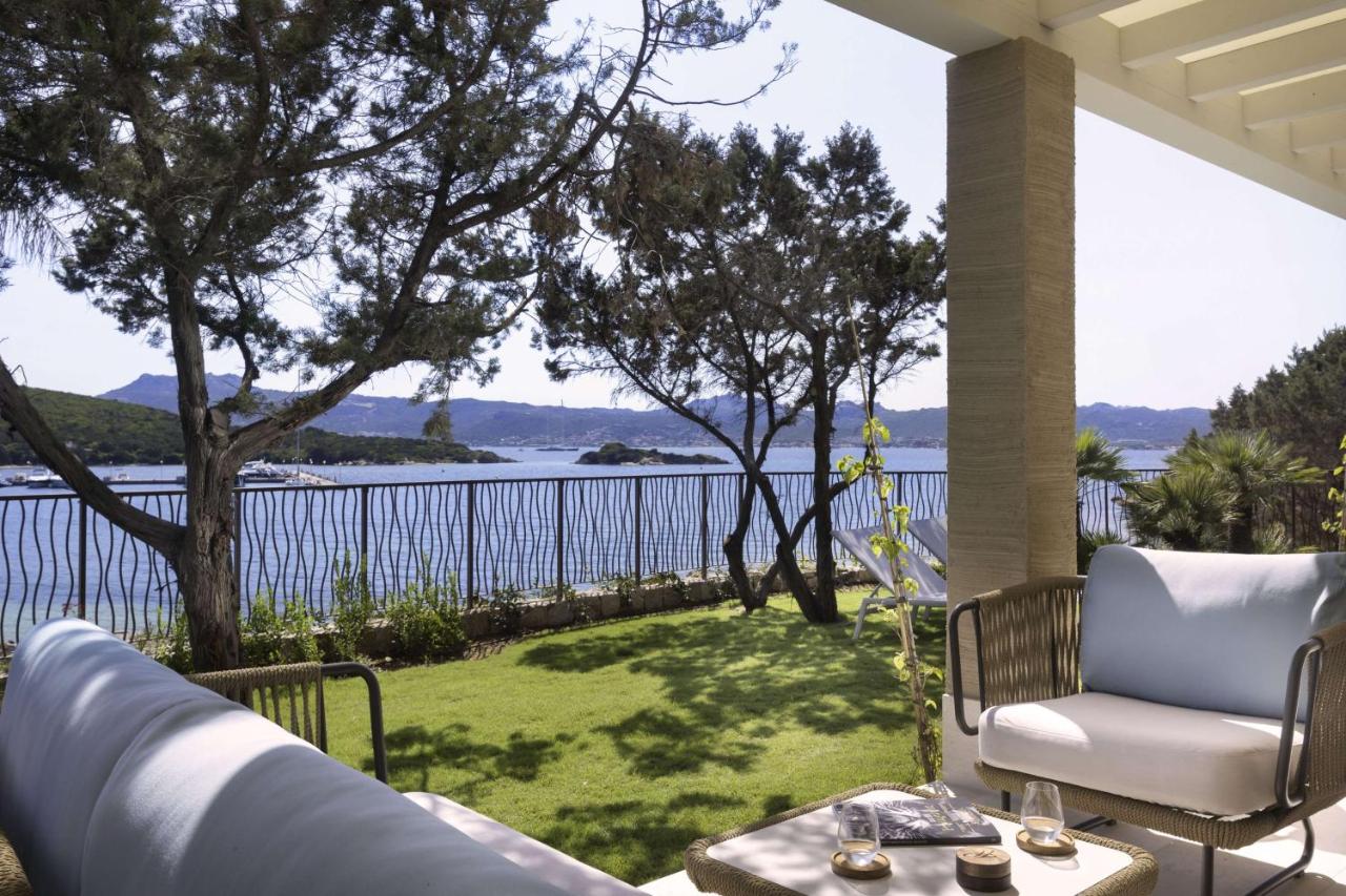 een veranda met een stoel en een tafel en uitzicht op het water bij 7Pines Resort Sardinia - A Destination By Hyatt in B