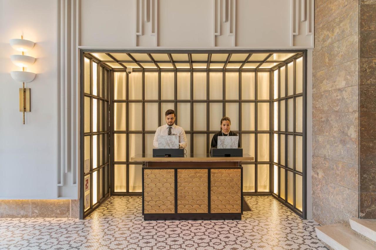 Twee mannen zitten aan een bureau met laptops. bij Pestana Lisboa Vintage City Center Suites in Lissabon