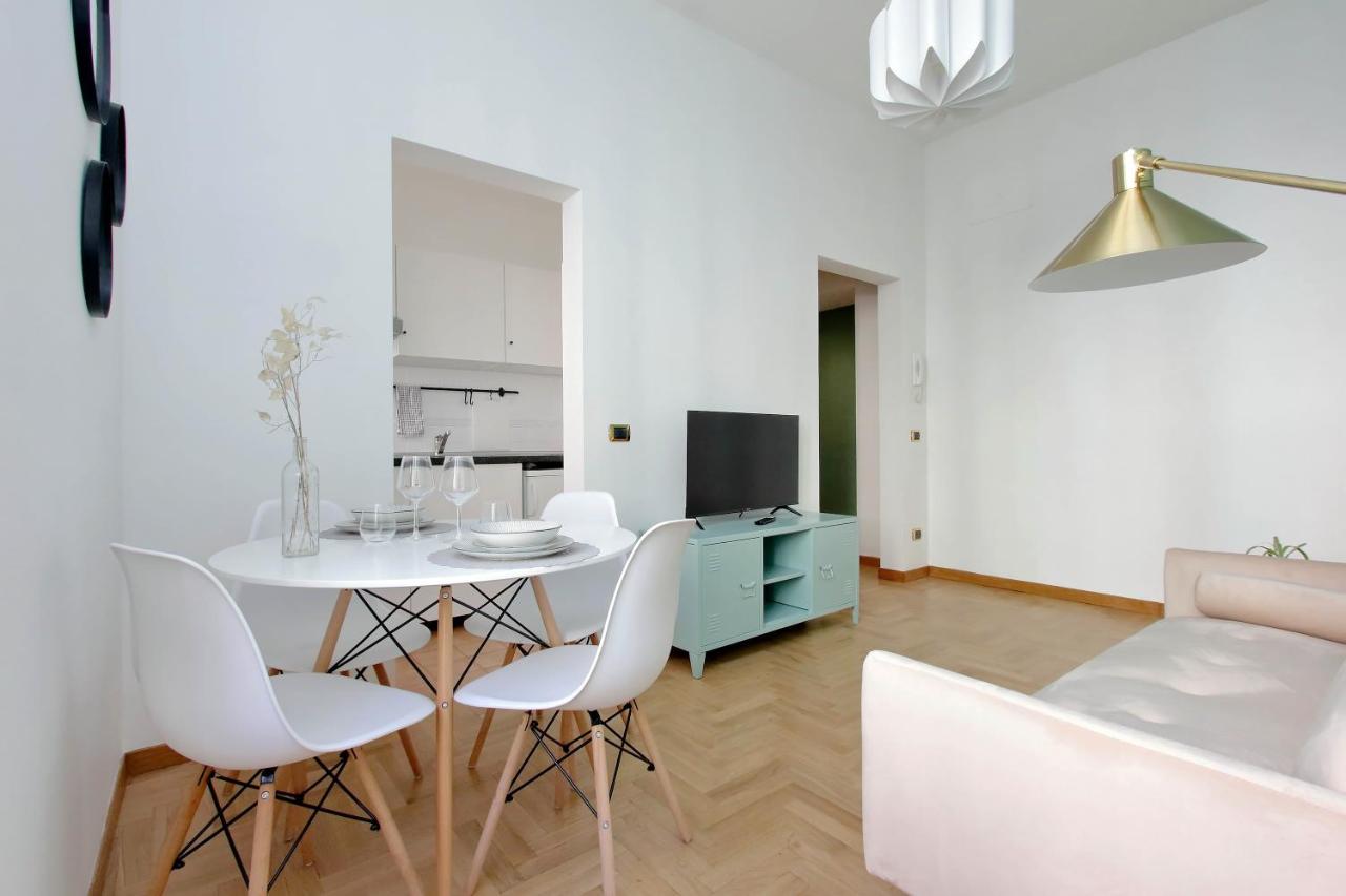 een woonkamer met een witte tafel en stoelen bij Take me Rome - Roman Forum Apartments in Rome