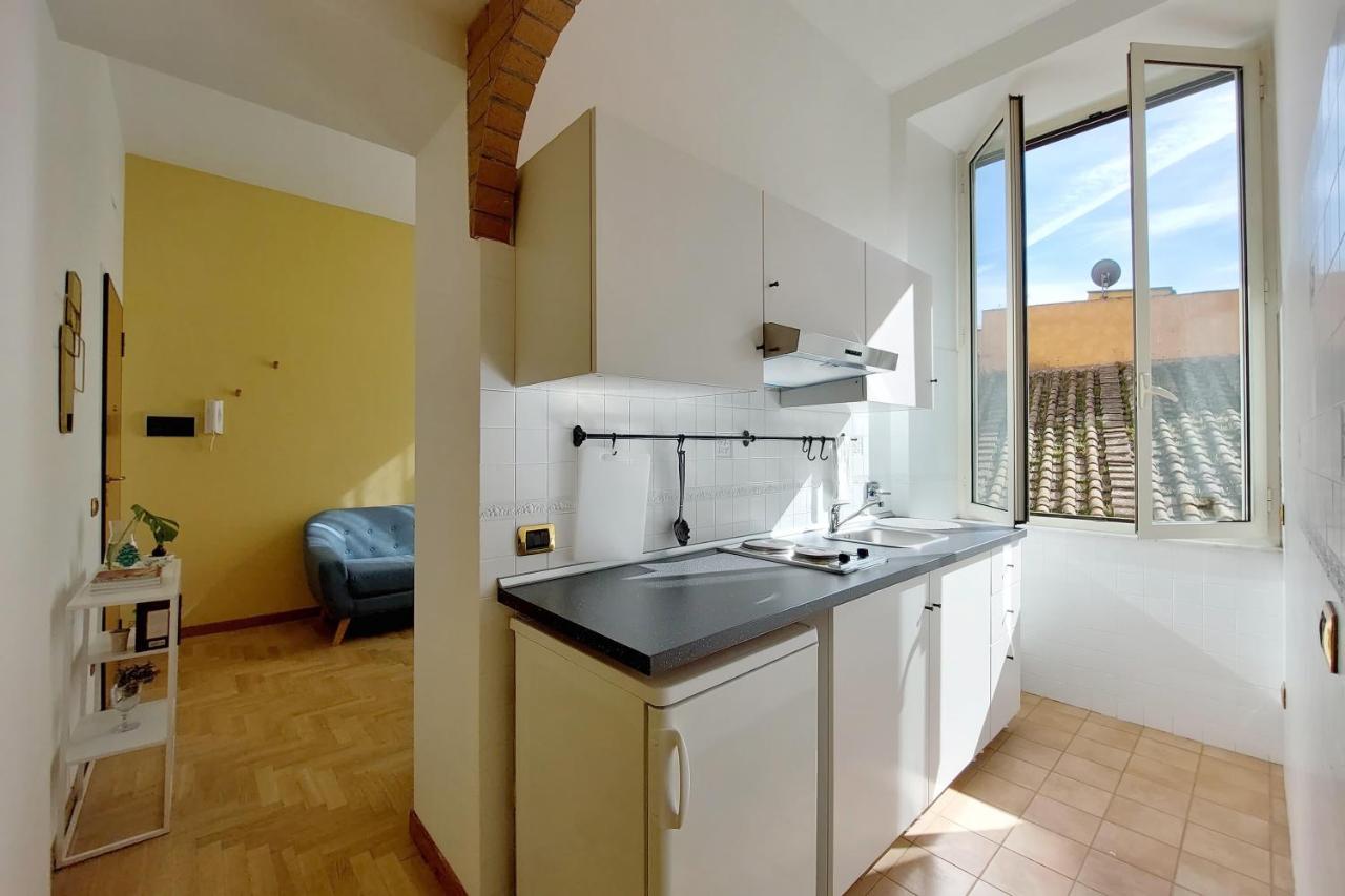 een keuken met witte kasten en een groot raam bij Take me Rome - Roman Forum Apartments in Rome