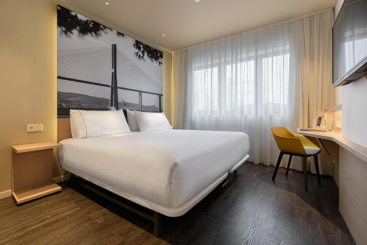 een groot wit bed in een kamer met een raam bij Ikonik Lisboa in Lissabon