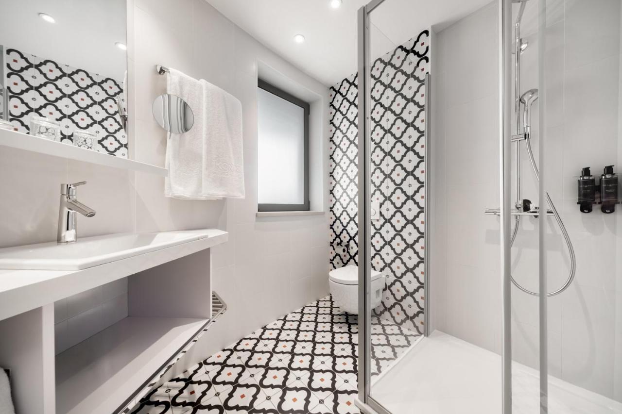 een badkamer met een douche, een toilet en een wastafel bij Ikonik Lisboa in Lissabon +35 foto's
