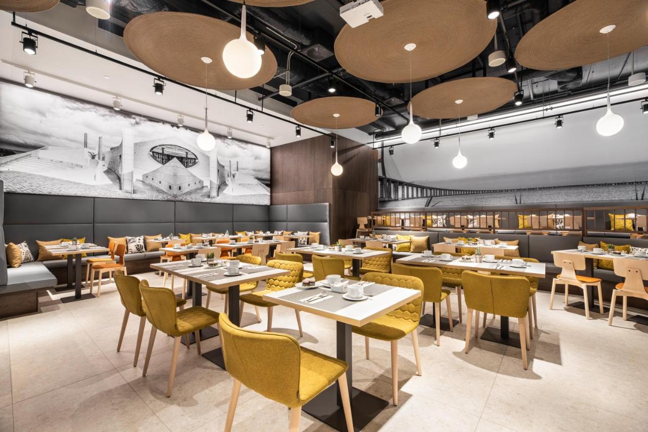 een restaurant met tafels en stoelen en een muurschildering bij Ikonik Lisboa in Lissabon