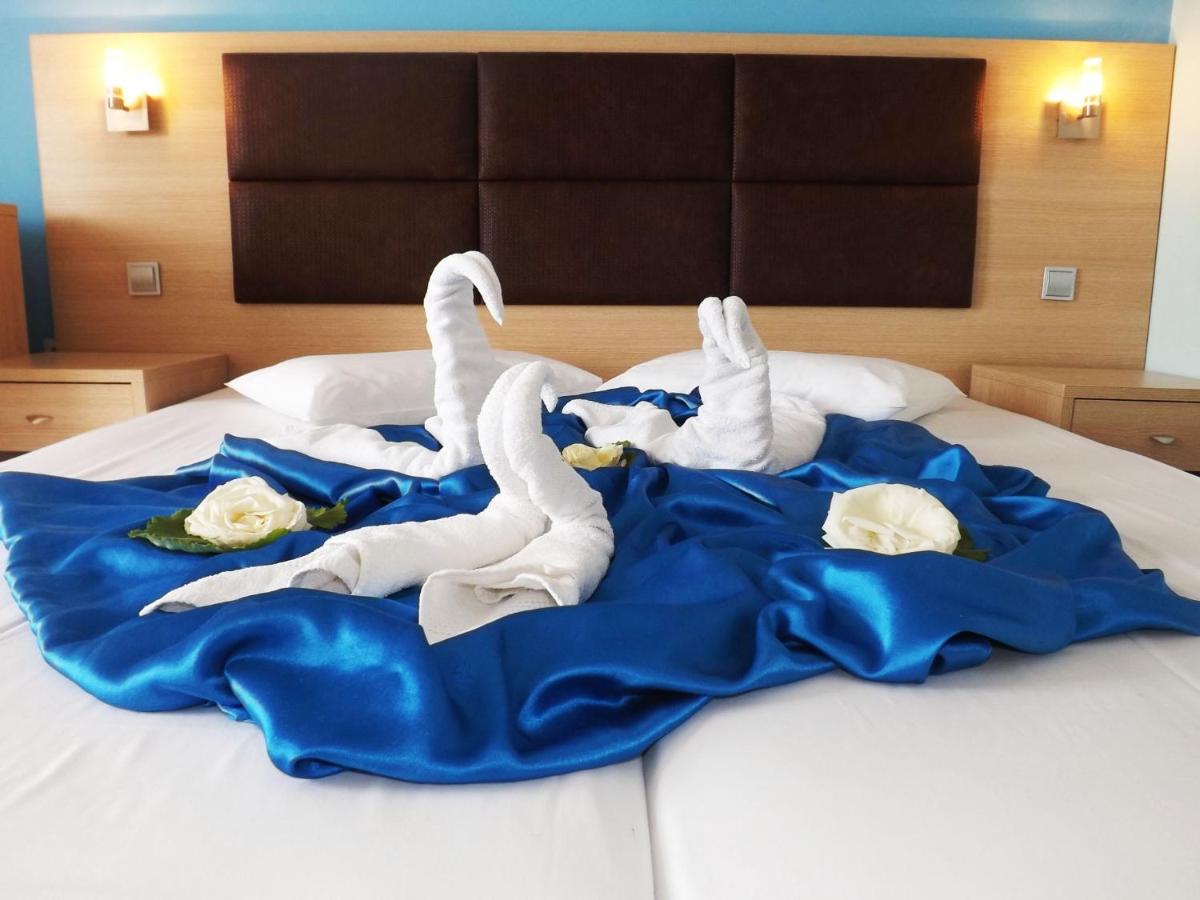 Twee witte zwanen liggen op een bed. bij Leonidas Hotel & Studios in Kos-stad