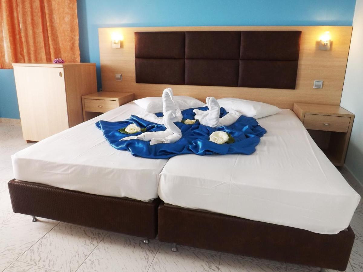 een slaapkamer met een bed waarop twee zwanen staan bij Leonidas Hotel & Studios in Kos-stad +76 foto's