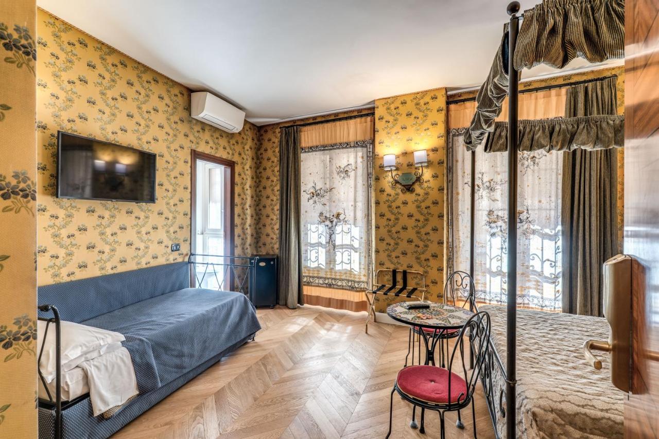 een slaapkamer met een blauw bed en een tafel bij Residenza Ave Roma in Rome
