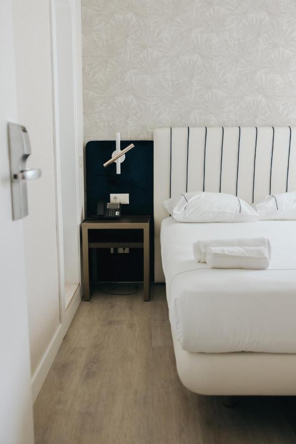een slaapkamer met een wit bed en een nachtkastje bij M'AR De AR Auria in Lissabon